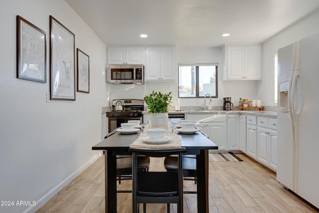 kitchen featuring a center island, sink, a breakfast bar area, white cabinetry, and stainless steel appliances