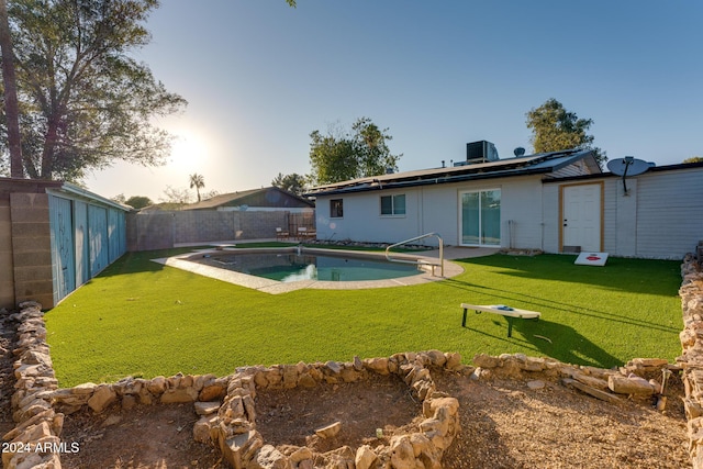 rear view of property with a fenced in pool, a yard, and cooling unit