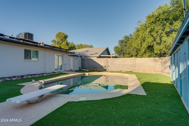 view of pool featuring a diving board, a yard, and cooling unit