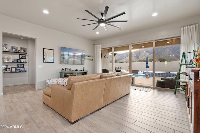 living room featuring ceiling fan and light wood-type flooring