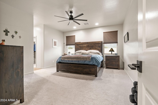 carpeted bedroom featuring ceiling fan, a spacious closet, and multiple windows