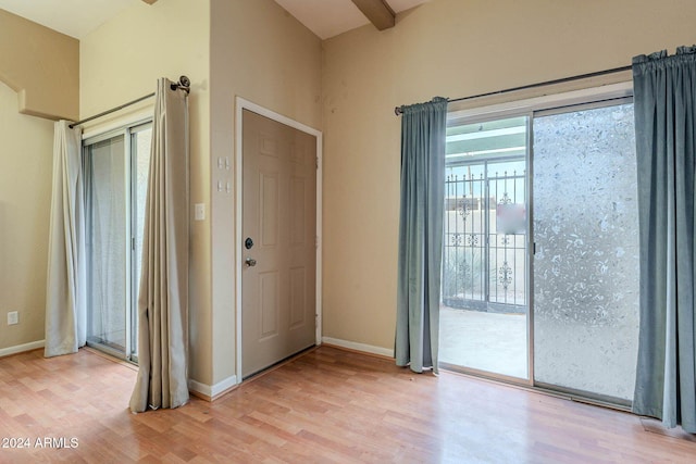 entryway featuring beamed ceiling and light hardwood / wood-style floors