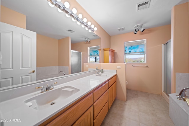 bathroom with dual sinks, tile floors, large vanity, and independent shower and bath