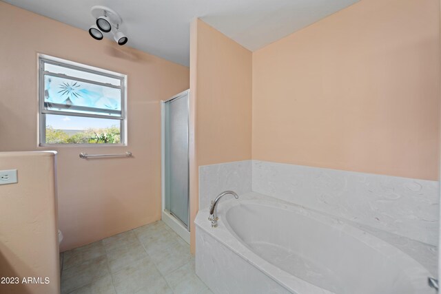 bathroom featuring tile floors and independent shower and bath