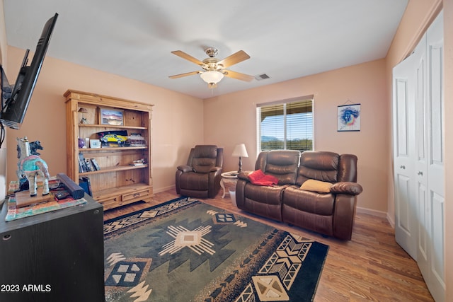 living room featuring ceiling fan and light wood-type flooring