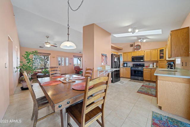 dining room with sink, ceiling fan, light tile floors, and lofted ceiling