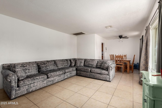 living room featuring light tile patterned floors, a ceiling fan, and visible vents