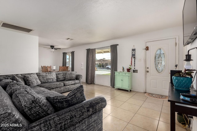 living area with light tile patterned floors, visible vents, and a ceiling fan