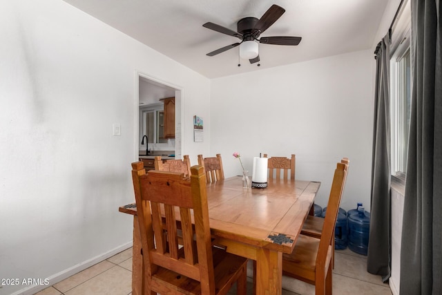 dining area featuring light tile patterned flooring, baseboards, and a ceiling fan