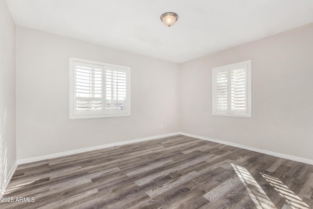 unfurnished room with a wealth of natural light and dark hardwood / wood-style flooring