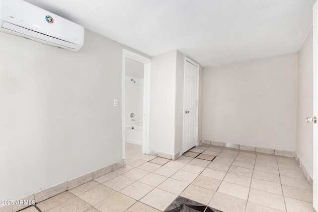 unfurnished room featuring a wall unit AC and light tile patterned flooring