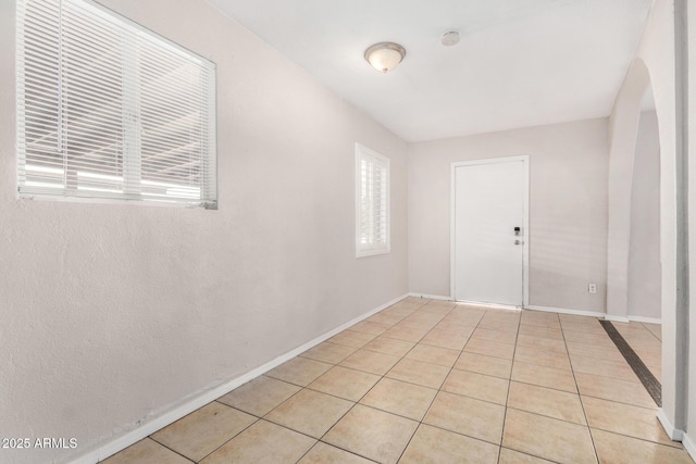 tiled empty room featuring a healthy amount of sunlight