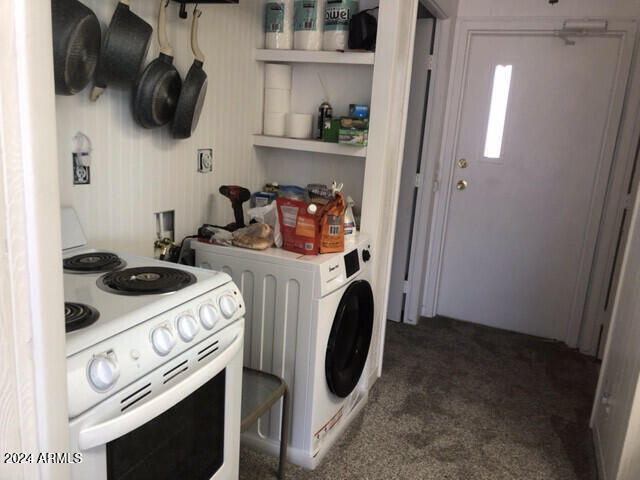 laundry area with washer / dryer and dark colored carpet