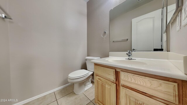 bathroom featuring toilet, vanity, and tile patterned flooring