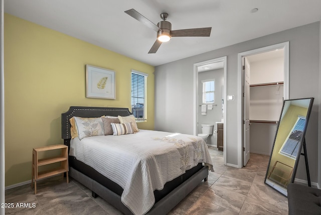 bedroom featuring a closet, ceiling fan, ensuite bathroom, and a spacious closet