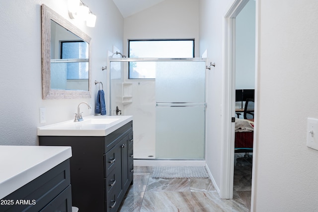 full bathroom with vanity, marble finish floor, lofted ceiling, and a stall shower