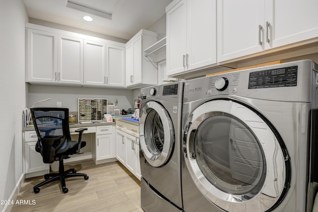 clothes washing area with cabinets, light wood-type flooring, and washer and dryer