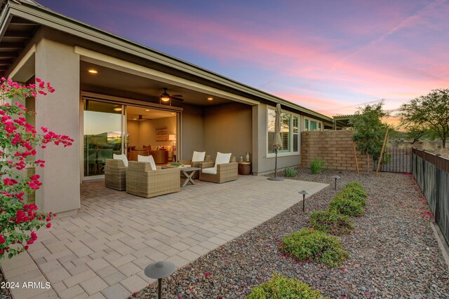 patio terrace at dusk featuring an outdoor living space and ceiling fan