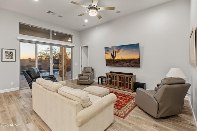 living room featuring ceiling fan and light hardwood / wood-style flooring