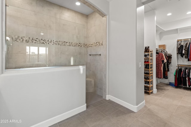 bathroom with tile patterned flooring and tiled shower