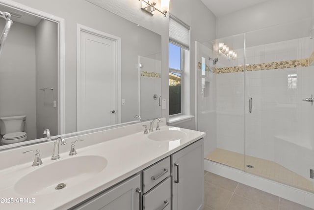 bathroom with tile patterned flooring, vanity, toilet, and a shower with door