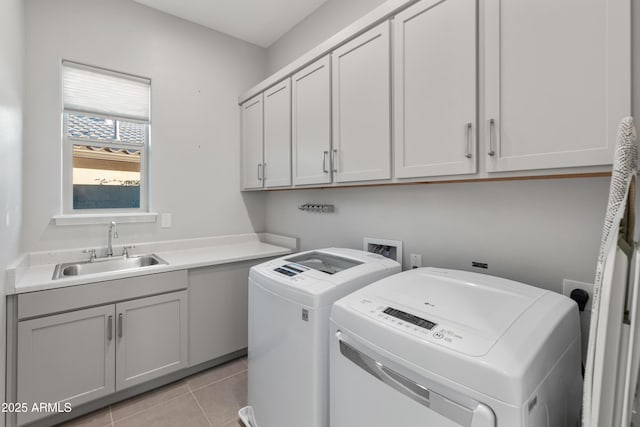 laundry room featuring washer and dryer, light tile patterned flooring, cabinets, and sink