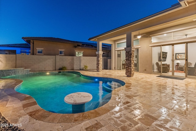 pool at twilight with pool water feature and a patio area