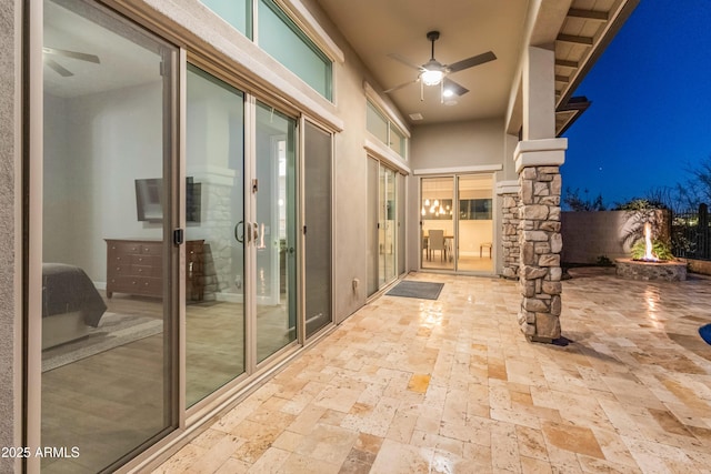 view of patio with ceiling fan and a fire pit