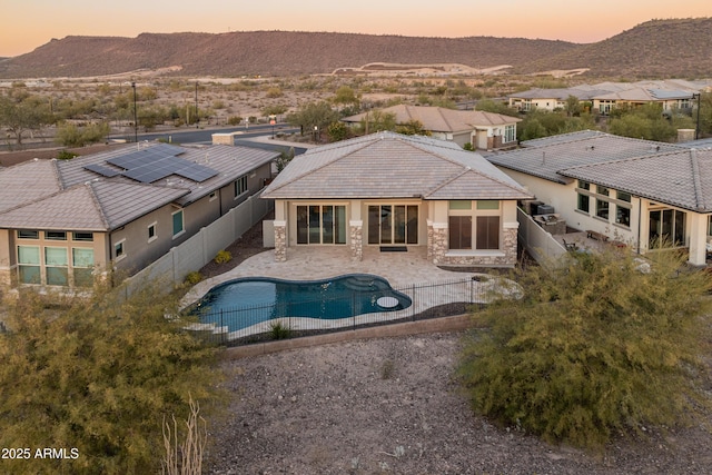 pool at dusk with a patio area