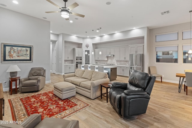 living room with ceiling fan and light wood-type flooring