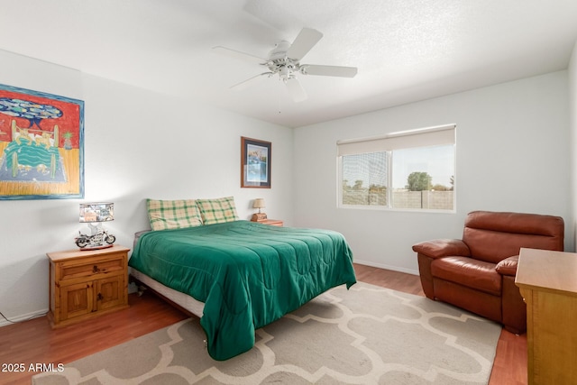 bedroom featuring light wood finished floors, ceiling fan, and baseboards