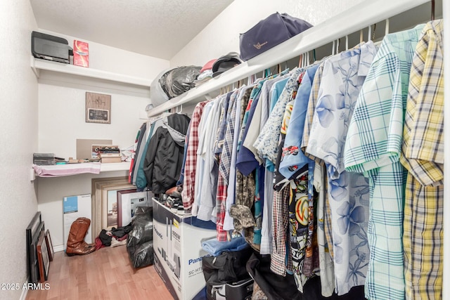 walk in closet with wood finished floors