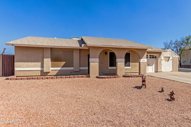 single story home with driveway, roof with shingles, an attached garage, and stucco siding