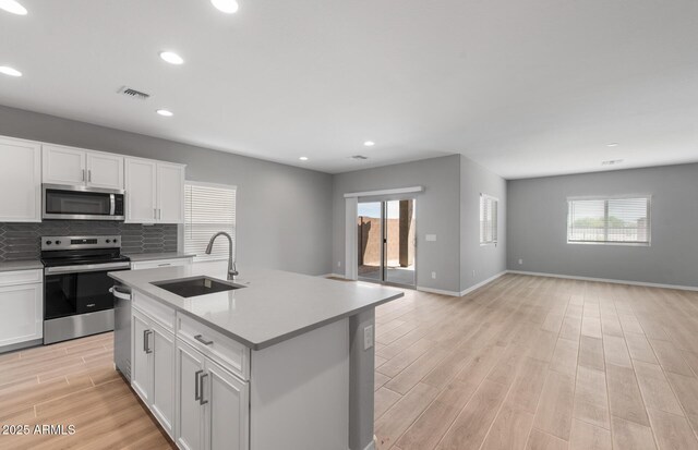 17809 W Getty Dr, Goodyear, AZ 85338 - kitchen with light wood finished floors, visible vents, a sink, appliances with stainless steel finishes, and open floor plan