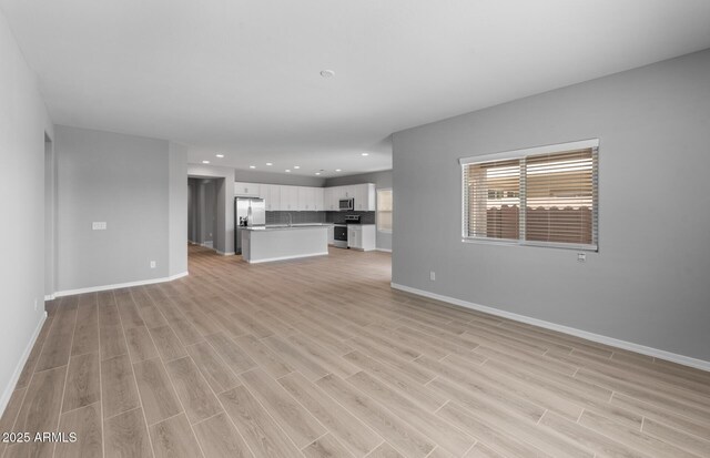 17809 W Getty Dr, Goodyear, AZ 85338 - unfurnished living room featuring recessed lighting, baseboards, and light wood-type flooring