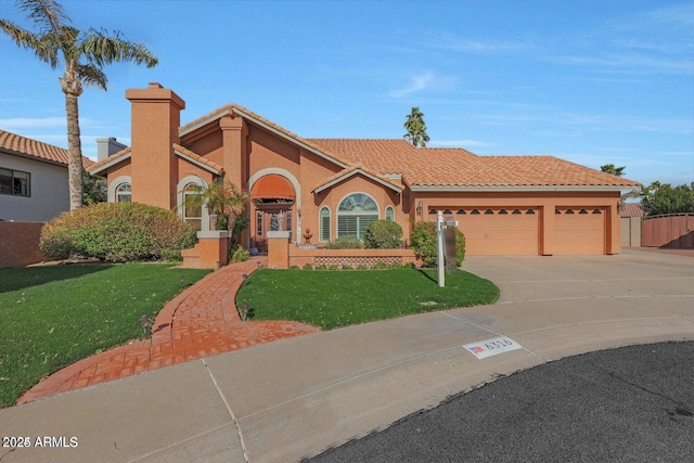 mediterranean / spanish home featuring a front yard and a garage