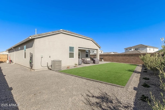 rear view of property featuring a fenced backyard, central air condition unit, a lawn, stucco siding, and a patio area