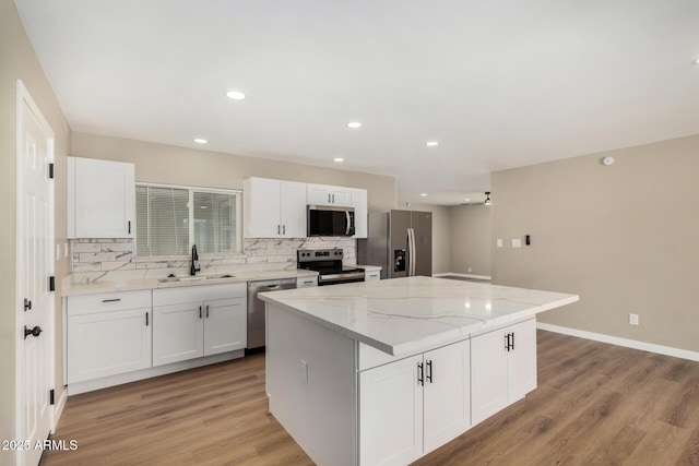 13805 N 31st Ave, Phoenix, AZ 85053 - kitchen with appliances with stainless steel finishes, decorative backsplash, a center island, white cabinets, and recessed lighting