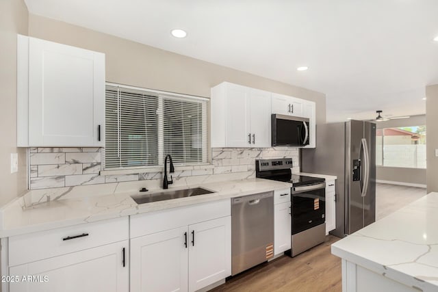 13805 N 31st Ave, Phoenix, AZ 85053 - kitchen with stainless steel appliances, decorative backsplash, light wood finished floors, white cabinetry, and recessed lighting
