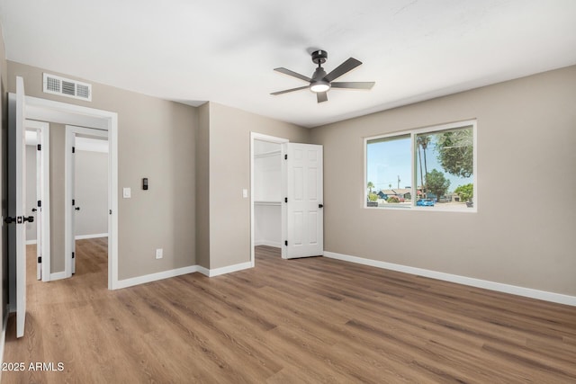 13805 N 31st Ave, Phoenix, AZ 85053 - unfurnished bedroom featuring light wood finished floors, a spacious closet, a closet, and ceiling fan
