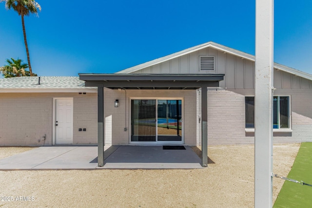13805 N 31st Ave, Phoenix, AZ 85053 - back of house with a patio area, brick siding, and board and batten siding
