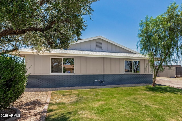 13805 N 31st Ave, Phoenix, AZ 85053 - view of front of house with brick siding, a front yard, board and batten siding, and a shingled roof