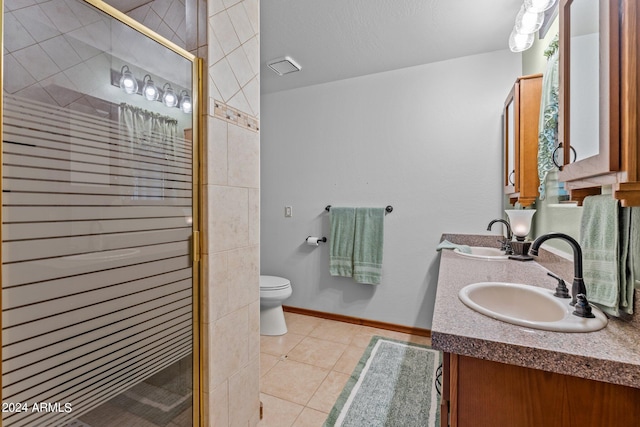 bathroom featuring vanity, toilet, an enclosed shower, and tile patterned floors