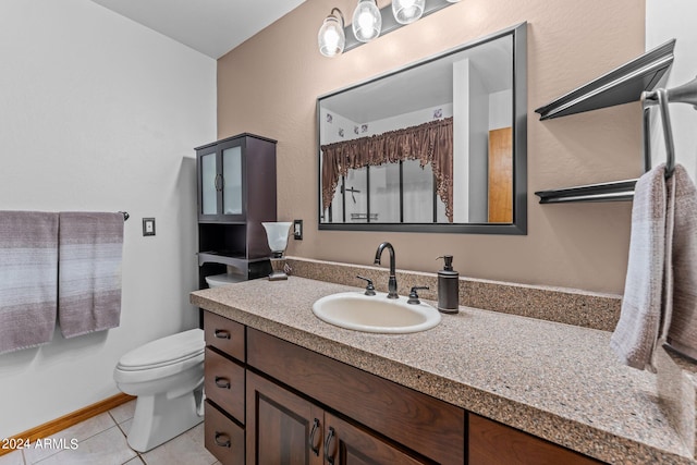 bathroom featuring tile patterned flooring, vanity, and toilet