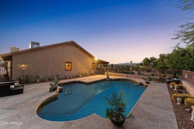 pool at dusk with a patio area