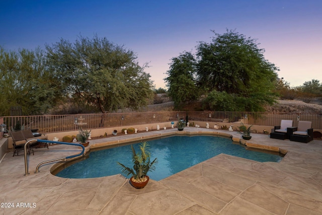 pool at dusk with a patio area