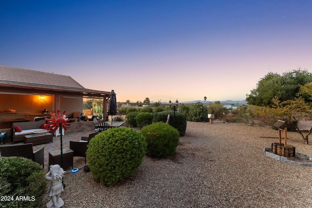 yard at dusk featuring an outdoor hangout area and a patio area