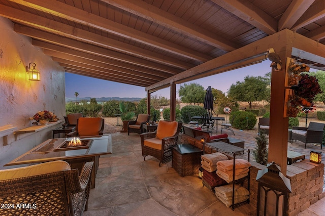 patio terrace at dusk featuring an outdoor living space with a fire pit