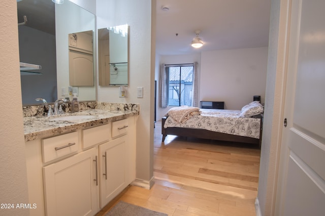 bedroom featuring light wood-type flooring and sink