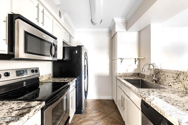 kitchen with light stone countertops, white cabinetry, sink, stainless steel appliances, and light tile patterned floors